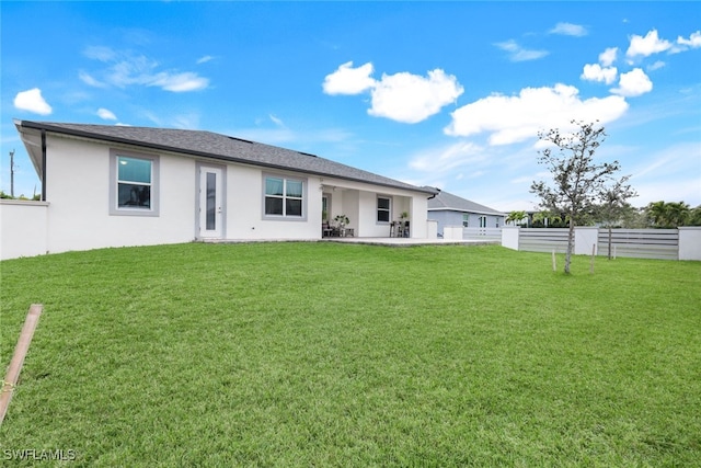 rear view of property featuring a patio area and a lawn