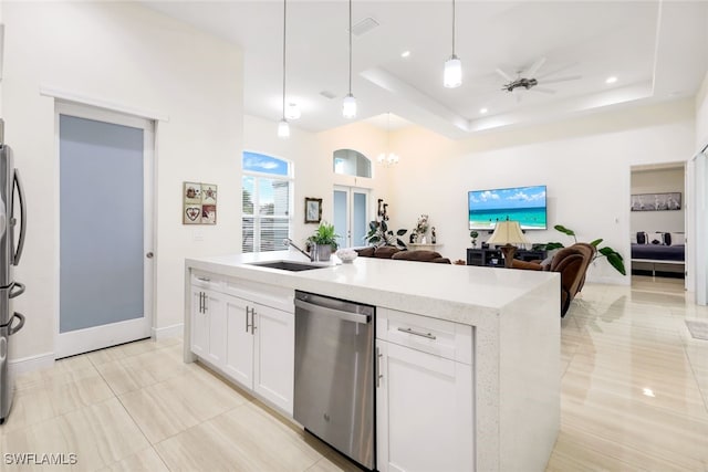 kitchen featuring stainless steel appliances, a raised ceiling, and white cabinets