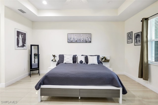 bedroom featuring a raised ceiling and ceiling fan