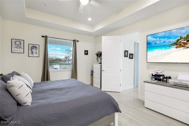 bedroom with a raised ceiling and ceiling fan