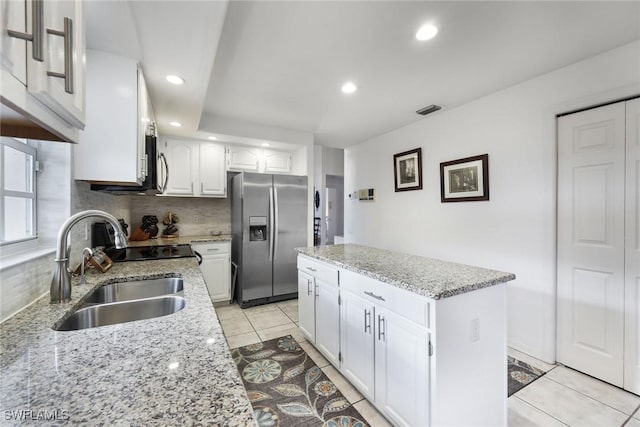 kitchen featuring sink, stainless steel refrigerator with ice dispenser, white cabinetry, and decorative backsplash