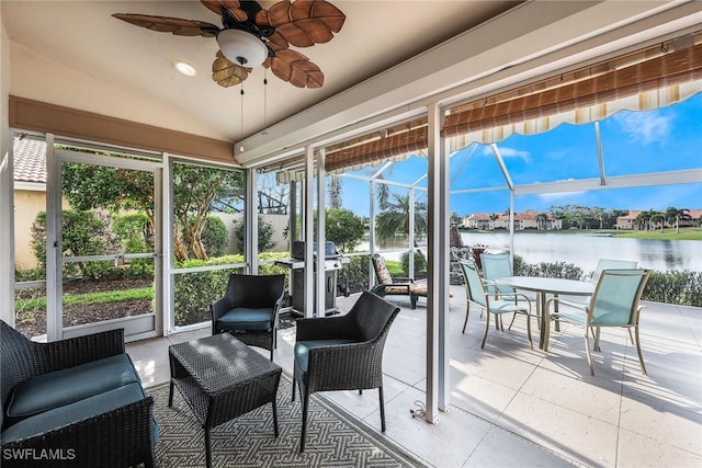 sunroom / solarium featuring ceiling fan, lofted ceiling, and a water view