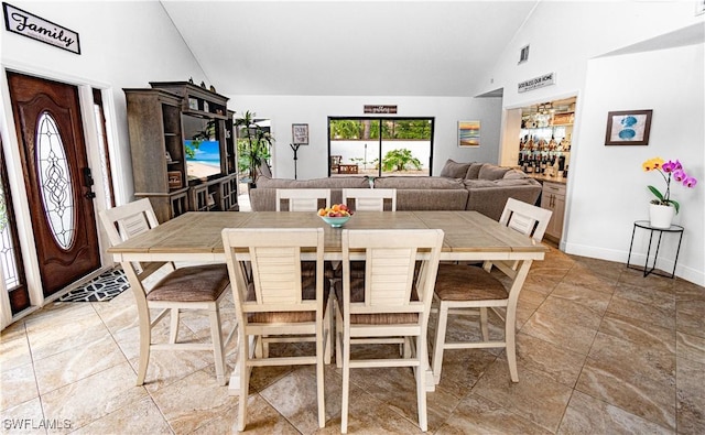 dining area with high vaulted ceiling