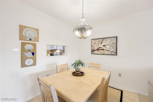 dining area featuring baseboards and a chandelier