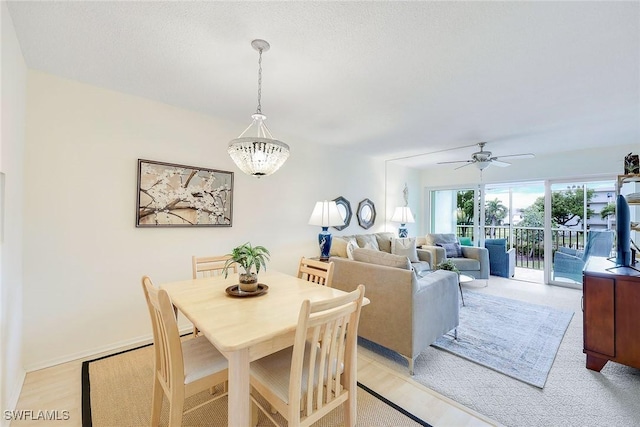 dining area featuring ceiling fan with notable chandelier and light hardwood / wood-style flooring