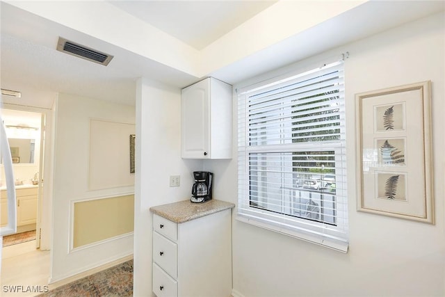 kitchen with visible vents and white cabinets