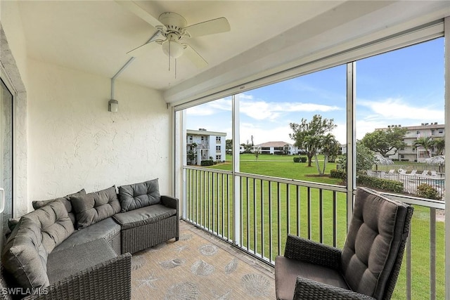 sunroom / solarium with a residential view and a ceiling fan