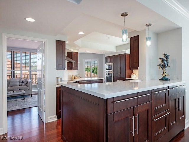 7425 Pelican Bay Blvd Unit 301, Naples, FL 34108 - kitchen featuring appliances with stainless steel finishes, dark hardwood / wood-style flooring, hanging light fixtures, kitchen peninsula, and dark brown cabinets