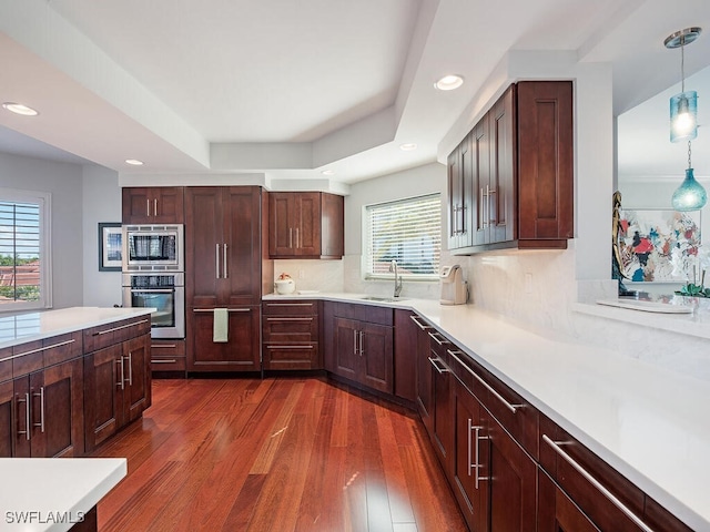 7425 Pelican Bay Blvd Unit 301, Naples, FL 34108 - kitchen featuring sink, hanging light fixtures, stainless steel appliances, tasteful backsplash, and dark hardwood / wood-style flooring