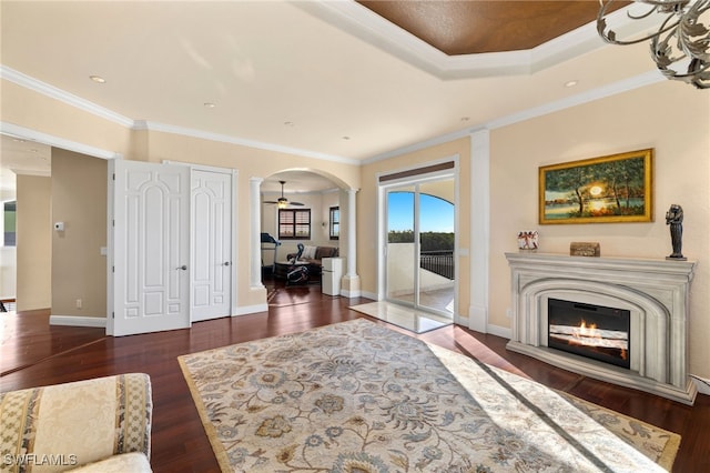 interior space featuring dark wood-type flooring, ornamental molding, and ornate columns