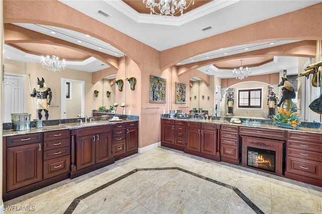 bathroom featuring vanity, an inviting chandelier, and a tray ceiling