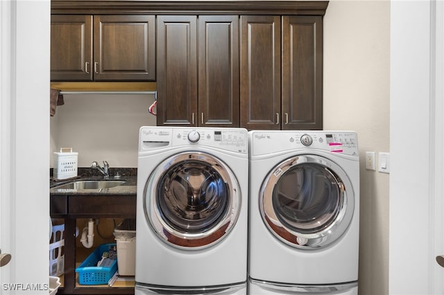 clothes washing area featuring cabinets, sink, and independent washer and dryer