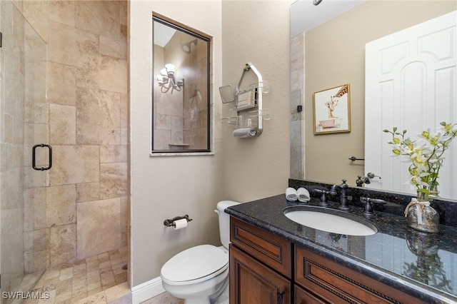 bathroom featuring vanity, toilet, and a shower with shower door