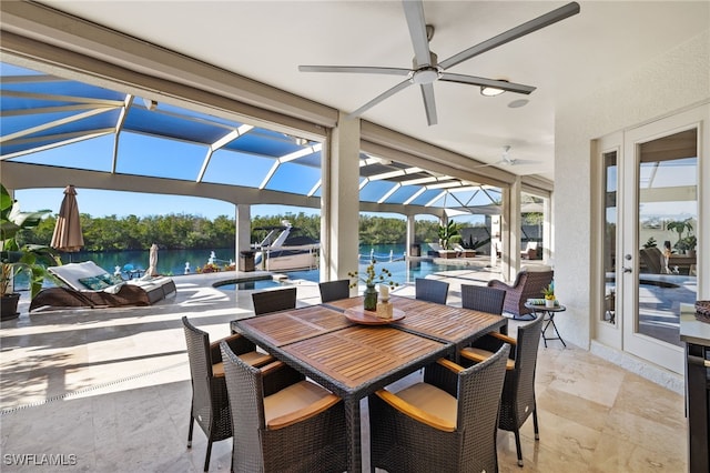 view of patio / terrace featuring a water view and a lanai