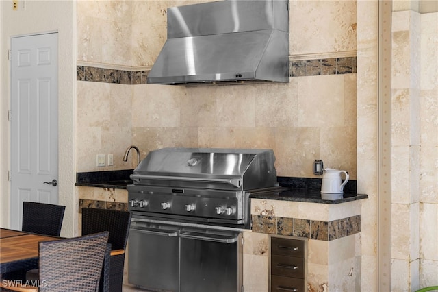 kitchen with sink, wall chimney range hood, tile walls, and decorative backsplash