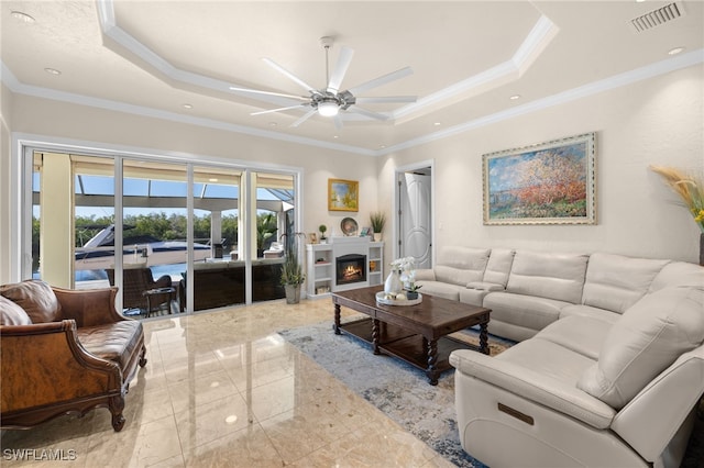 living room with ceiling fan, ornamental molding, and a raised ceiling