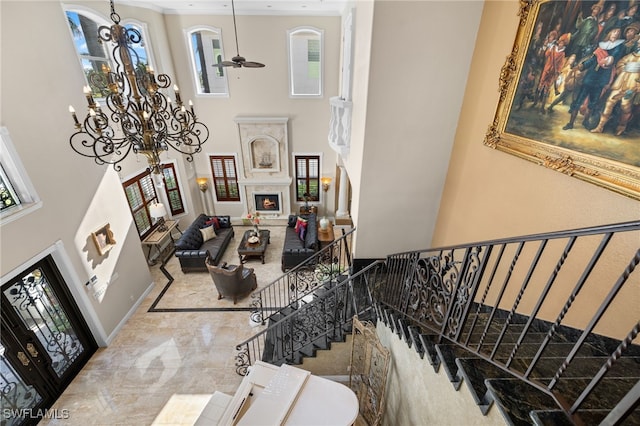 stairway with a towering ceiling and a chandelier