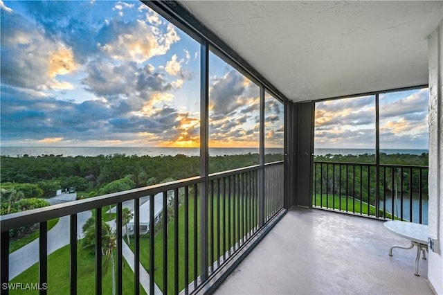 unfurnished sunroom featuring a water view