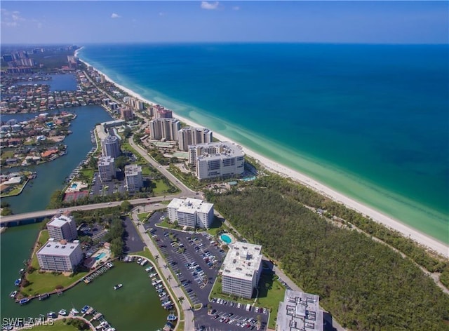 drone / aerial view featuring a water view and a beach view