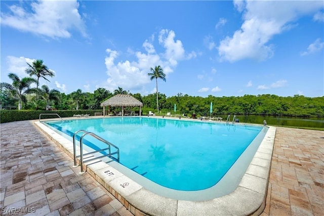 view of pool featuring a gazebo, a water view, and a patio area