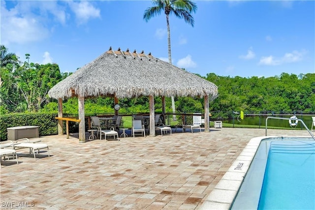 view of swimming pool featuring a gazebo, a patio area, and a water view