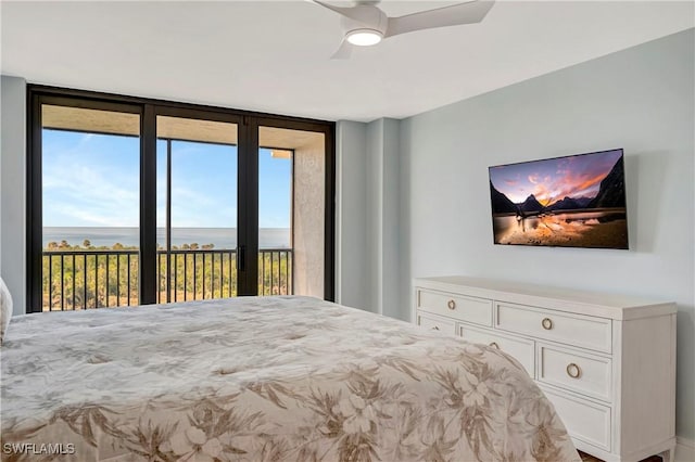 bedroom with access to outside, ceiling fan, and a water view