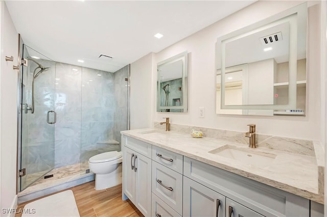 bathroom featuring vanity, wood-type flooring, toilet, and walk in shower