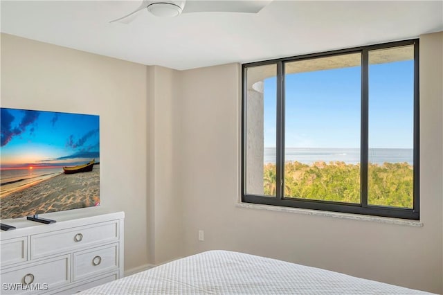 bedroom featuring a water view and ceiling fan