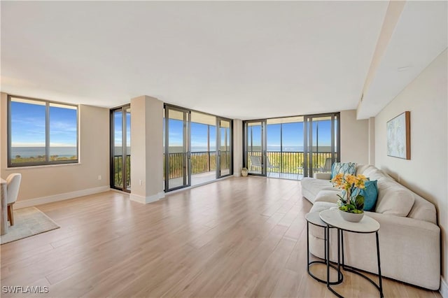 living room featuring floor to ceiling windows and light hardwood / wood-style floors