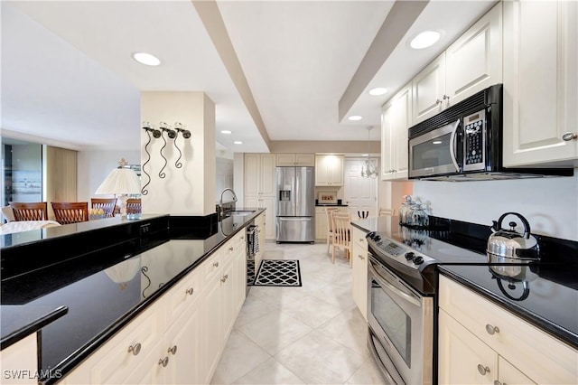 kitchen with light tile patterned floors, stainless steel appliances, sink, and white cabinets