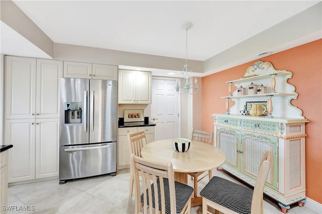 kitchen with hanging light fixtures, stainless steel refrigerator with ice dispenser, a notable chandelier, and white cabinets