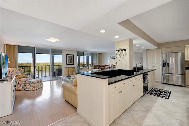 kitchen with sink, stainless steel fridge, and cream cabinets