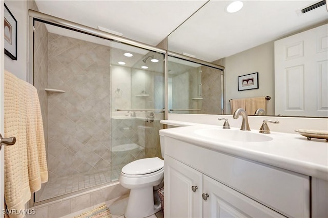 bathroom with vanity, toilet, tile patterned floors, and a shower with shower door