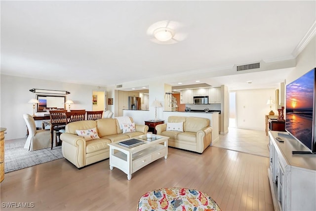 living room featuring ornamental molding and light hardwood / wood-style flooring