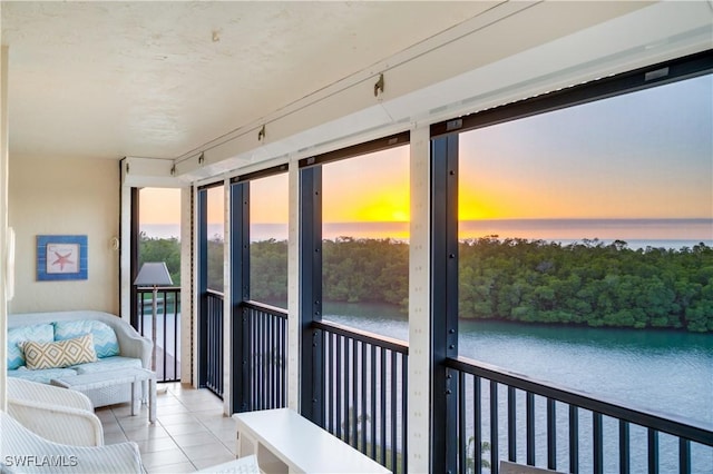 sunroom / solarium featuring rail lighting and a water view