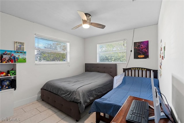 bedroom with tile patterned flooring, multiple windows, a ceiling fan, and baseboards