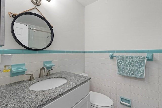 bathroom with tile walls, toilet, and vanity