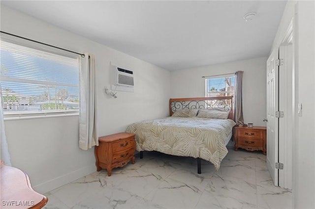 bedroom featuring baseboards, marble finish floor, and a wall mounted AC