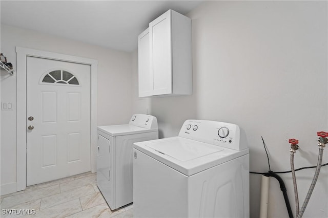 washroom with cabinet space and washer and dryer