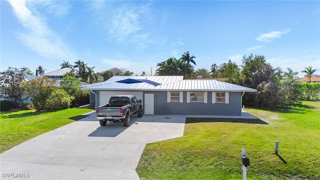 ranch-style home featuring stucco siding, concrete driveway, metal roof, and a front lawn