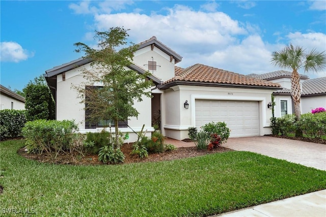 mediterranean / spanish-style home featuring a tiled roof, decorative driveway, an attached garage, a front lawn, and stucco siding