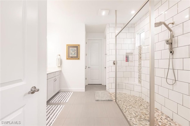full bath featuring baseboards, tile patterned floors, a walk in shower, and vanity