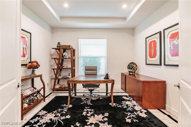 office space with a raised ceiling and baseboards