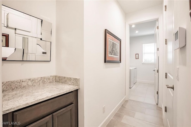 hallway with light tile patterned flooring and baseboards