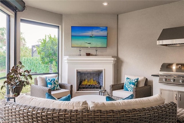 living area with a warm lit fireplace and a textured wall