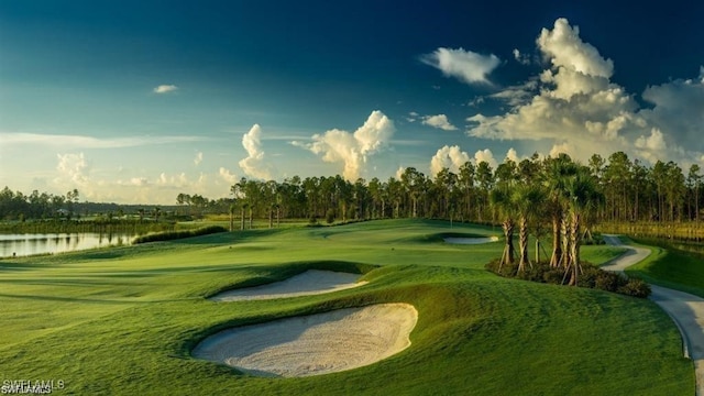 view of home's community featuring view of golf course, a water view, and a yard