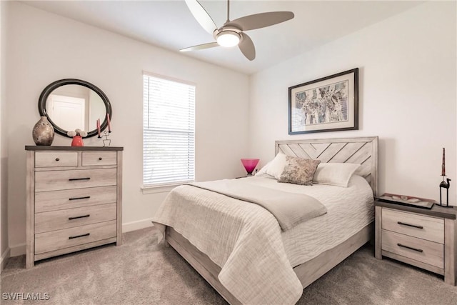bedroom with light carpet, baseboards, and a ceiling fan
