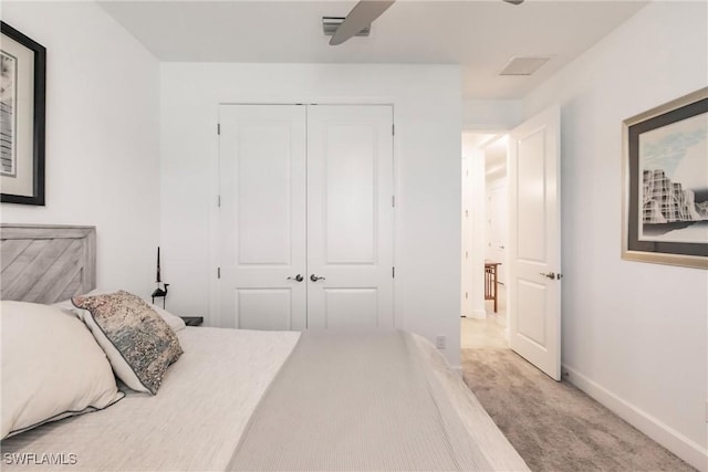carpeted bedroom with a ceiling fan, baseboards, a closet, and visible vents