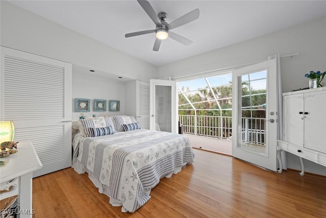 bedroom with access to exterior, hardwood / wood-style flooring, and ceiling fan