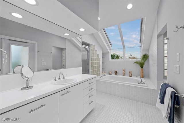 bathroom with vanity, lofted ceiling, tiled bath, and tile patterned floors